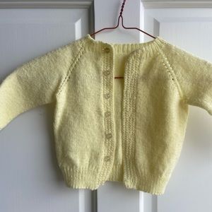 Soft yellow hand knitted cardigan sweater.